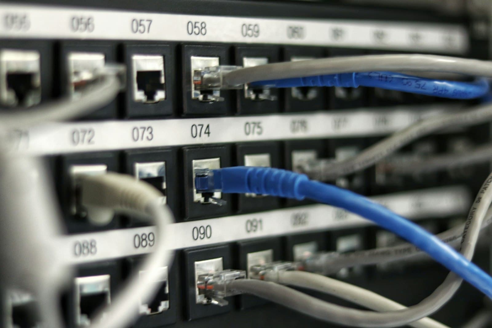 Numbered patch panel with ethernet cables plugged into ports