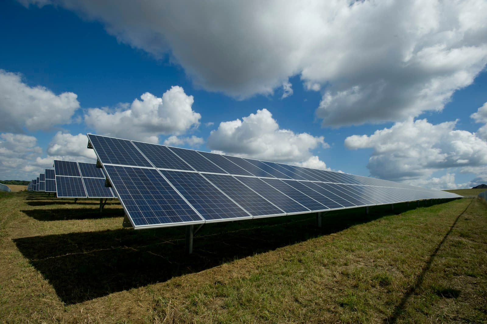 Rows of solar panels under a bright sky