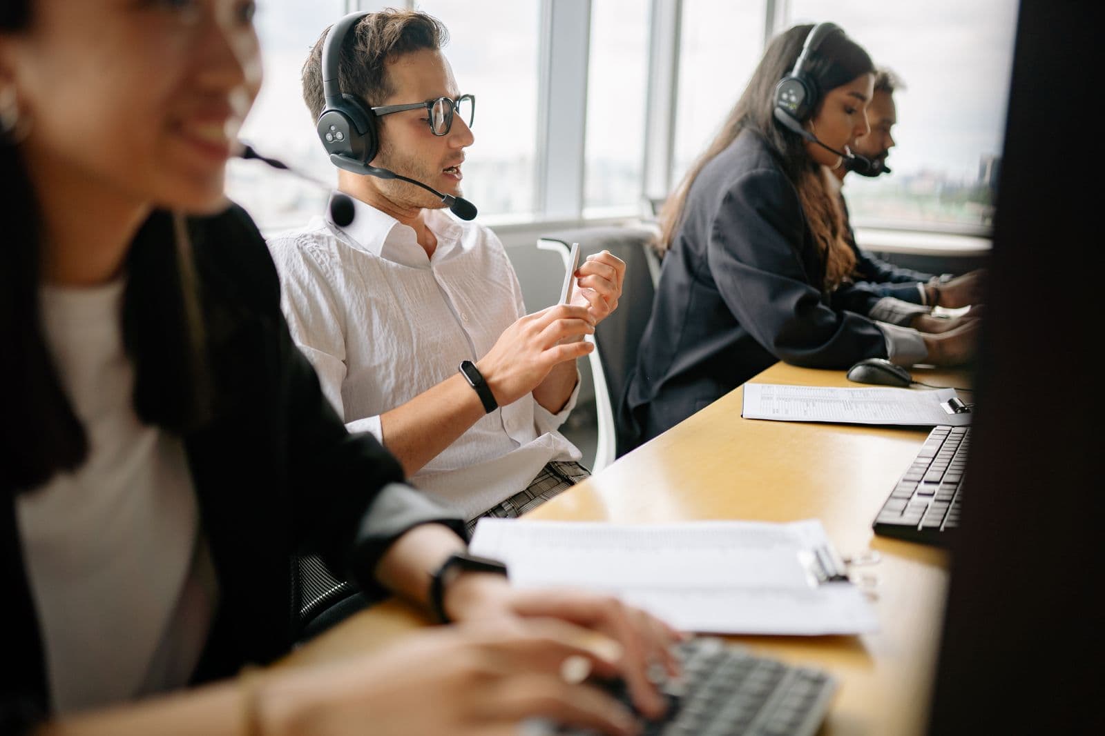 Contact center agents wearing headsets in a bright office